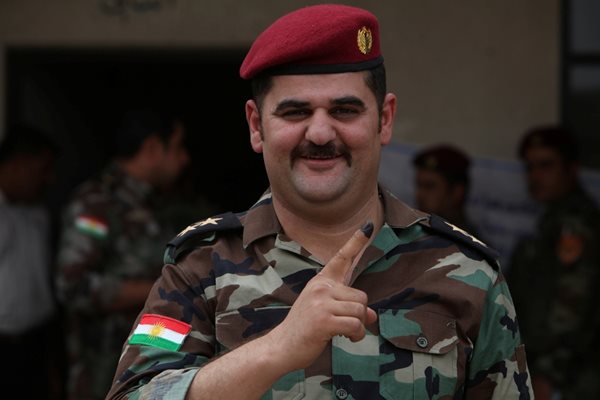 Войник от кюрдските сили пешмерга показва оцветения си пръст, с който е гласувал на референдума. СНИМКИ: РОЙТЕРС