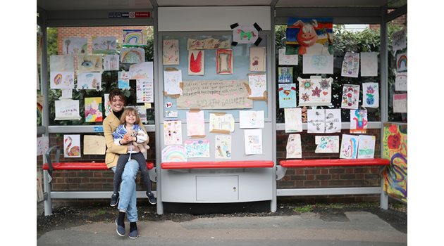 Майка и 4-годишната и? дъщеря Роузи седят на автобусна спирка в Лондон, където детето е подредило изложба с рисунки за коронавируса.
СНИМКА: РОЙТЕРС