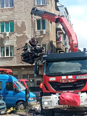 Кран взема возилото, за да го натовари.