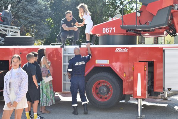 Хлапетата са щастливи, че се докосват до истинско поротивопожарно оборудване.