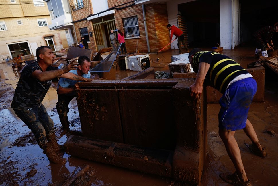 Spaniards move water-damaged furniture in Utiel. PHOTOS: Reuters