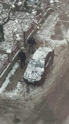 Шофьор си чисти снега от колата с мотика