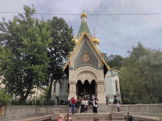 Хора палят свещи и оставят цветя пред храма.