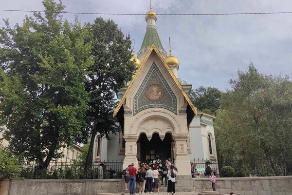 Хора палят свещи и оставят цветя пред храма.