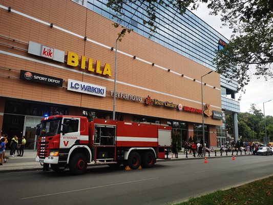 Пожарен автомобил стои пред изпразнения мол.