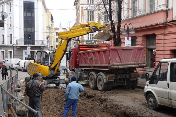 Багер изгребва калта и я товари в камион.