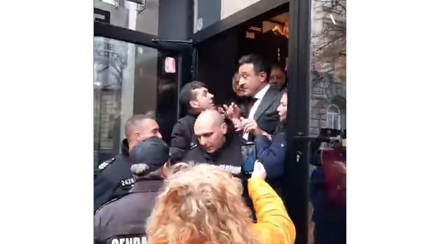 Кадър от момента, в който Даниел Лорер излиза от кафенето, пазен от полицаи, докато протестиращите го бутат и притискат.

СТОПКАДЪР: ФЕЙСБУК