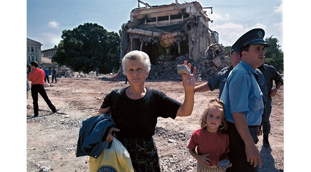 Жена показва парче от разрушения мавзолей, което си е взела за спомен.
