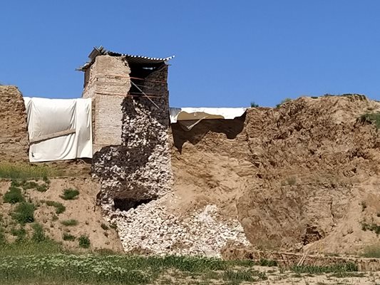 Най-отгоре античният градеж е затулен с ламарини, а отстрани се веят платнища.