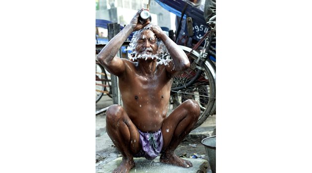 Когато човек иска да поддържа лична хигиена, той винаги намира начин - както прави този водач на рикша в Делхи, който се къпе на улицата