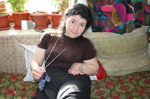 Ася продължава да плете терлици, като си помага с краката.