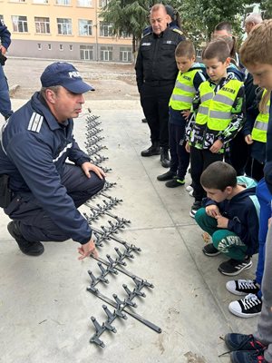 Полицай показва едно от техническите средства за спиране на нарушители на пътя, които се опитват да избягат.