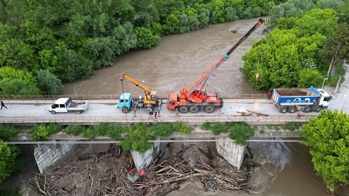 Със специална техника премахват довлечените клони и дървета, затапващи моста СНИМКА: Община Велико Търново
