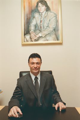Жоро Илиев в офиса си, а над него има портрет на брат му Васил