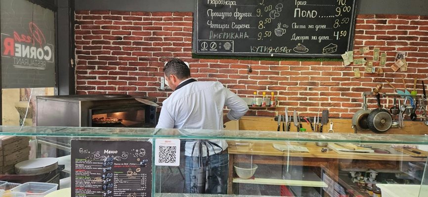 Павел Михайлов слага пицата в пещта.