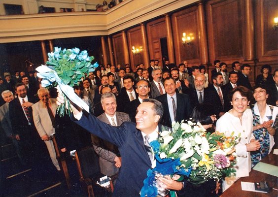Иван Костов триумфира в пленарната зала, след като през 1997 г. СДС печели убедително парламентарните избори. Получава сини букети и бурни аплодисменти. Предстои му да състави правителство