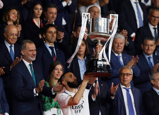Крал Фелипе VI (вляво) гледа как Карим Бензема се радва на 33-ия трофей в кариерата си като футболист, което го прави рекордьор на “Реал” и Франция.
Снимка: Ройтерс