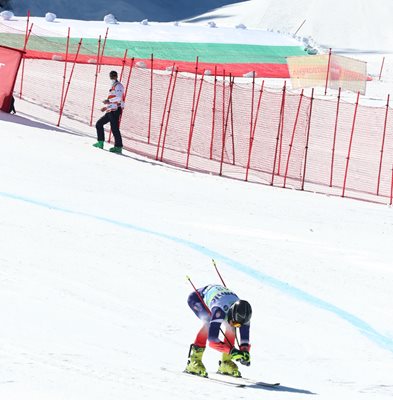 Българският скиор Косьо Стоилов, който завърши 24-и в супергинатския слалом, финишира на фона на огромния национален флаг.