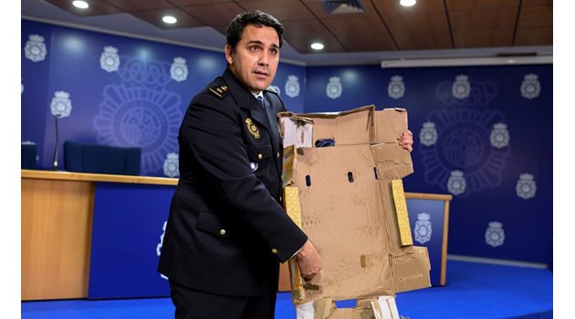 Испански полицай показва един от кашоните с лайм, в който е крита дрога.

