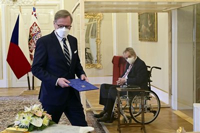 Чешкият президент Милош Земан назначи новия премиер Петър Фиала, като по време на цереманията седеше в инвалиден стол в специална пластмасова “стаичка”, защото е болен от COVID-19. Чехия е една от европейските страни, в които е засечен омикрон. СНИМКА: РОЙТЕРС