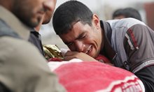 Мъж плаче над тялото дете, жертва на  ИДИЛ в Мосул