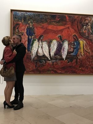 Влюбена двойка се целува пред платно на Марк Шагал в музея.