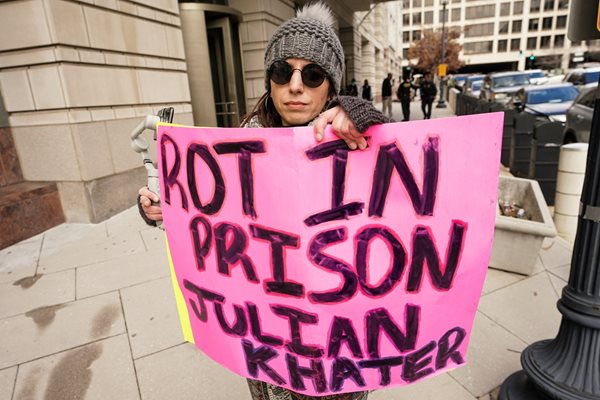 Жена държи пред съдебната зала плакат, на който пише: "Гний в затвора, Джулиан Хейтър!". Снимка: Ройтерс
