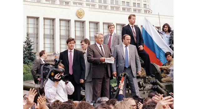 Борис Елцин е качен върху бронетранспортьор пред Белия дом в Москва и изнася реч към руския народ. Под него са журналисти, подали микрофони, а един от тях държи чука от “Стената”. Тази снимка беше на 19-а стр. в броя на “24 часа” от 21 август.