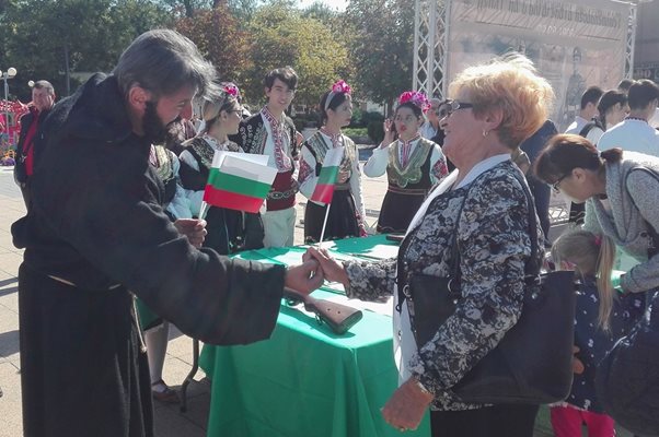 Актьор в ролята на Паисий Хилендарски подарява българското знаме на бургазлийка.Снимка:Авторът