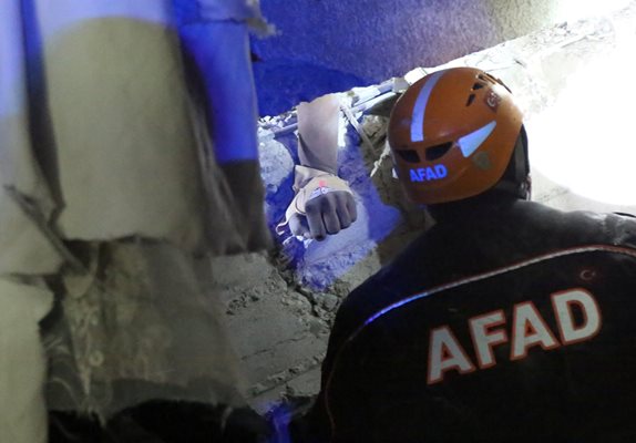 Спасители се опитват да измъкнат оцелял човек сред развалините. СНИМКА: РОЙТЕРС