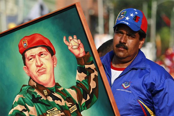 Николас Мадуро държи на митинг портрет на Уго Чавес.
