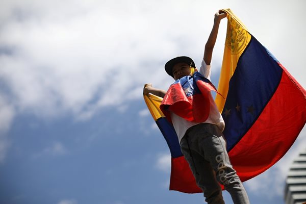 Момче държи знамето на Венецуела  СНИМКА: Ройтерс