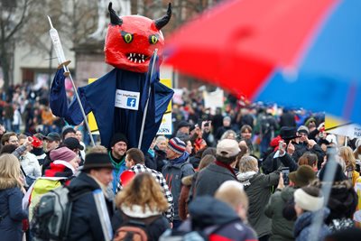 Germans carry a model of the devil with a syringe during a protest against the restrictive measures in the city of Kassel.  PHOTO: Reuters