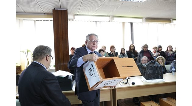 Председателят на изборната комисия проф. Гърчев показва протоколите.