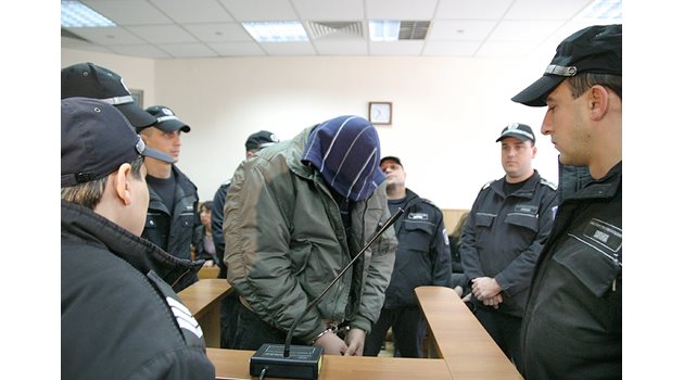 Полицаи водят в съда Виктор Траянов. След присъдата той е прибран в затвора.