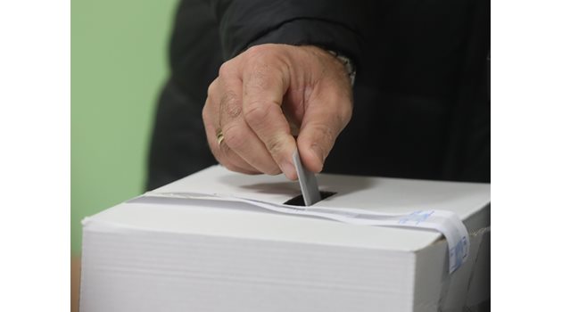 Избирател пуска разписката от машината в изборната урна. СНИМКА: "24 ЧАСА"