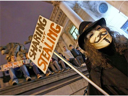 Активист на хакерската група “Анонимните” протестира в Брюксел срещу АСТА с плакат “Да споделяш не значи да крадеш”.
СНИМКИ: РОЙТЕРС