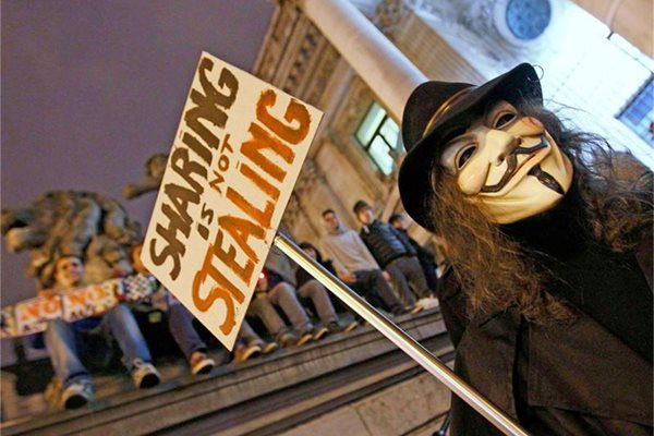 Активист на хакерската група “Анонимните” протестира в Брюксел срещу АСТА с плакат “Да споделяш не значи да крадеш”.
СНИМКИ: РОЙТЕРС