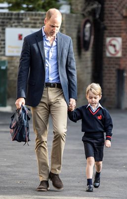 Британският принц Уилям стиска здраво ръката на сина си Джордж на първия му учебен ден миналата година.