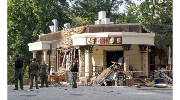 Разследващи търсят улики сред рухналите стени на кафенето, в което Захарченко бе убит с бомба.
