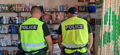 Полицаи проверяват магазин за хранителни стоки.