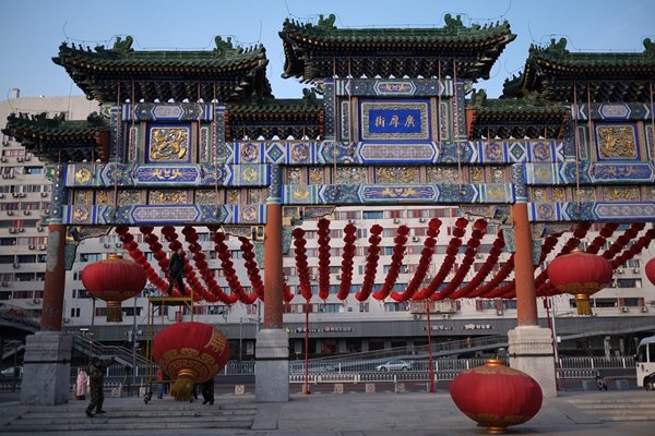 Работници развалят украсата в Пекин, след като празненствата за Китайската нова година бяха отменени.