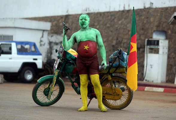  Привърженик на Камерун пристига с мотора си за мача срещу Буркина Фасо на откриването, спечелен с 2:1 от домакините
