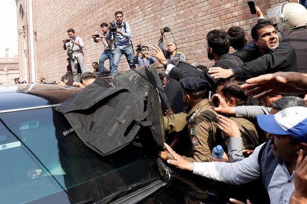 Пакистански полицаи проправят път за автомобил, превозващ бившия премиер Имран Хан след явяването му в съд в Лахор. 
Снимка: Ройтрес