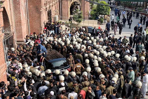 Пакистански полицаи проправят път за автомобил, превозващ бившия премиер Имран Хан след явяването му в съд в Лахор. 
Снимка: Ройтрес
