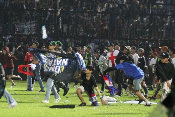 Фенове нахлуват на стадиона в Индонезия.