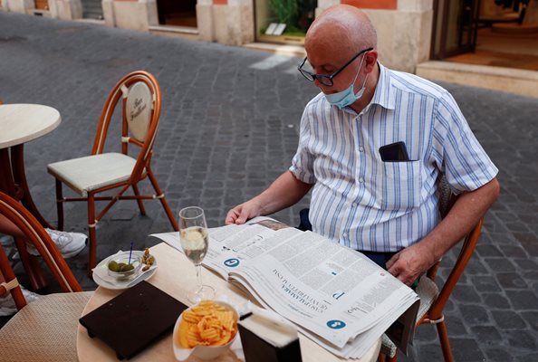 Италианец чете вестник, за да следи развитието на пандемията.
