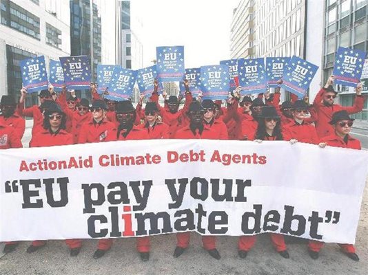 Еколози протестират в Брюксел с плакат , който иска ЕС да плати своя "климатичен дълг".
СНИМКА: РОЙТЕРС