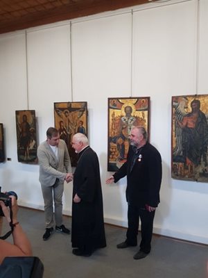 Отец Борис Беров от бургаския храм "Св.Богородица"  поздравява Александър Рабинович. Зад него е отличеният художник и реставратор Климент Атанасов.