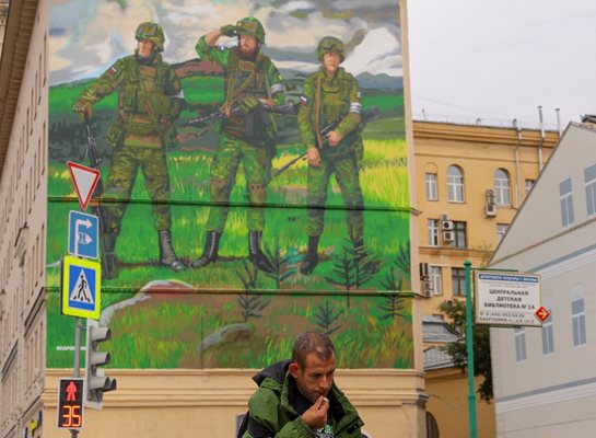 Руснак минава покрай графит, възхваляващ армията в Москва.
СНИМКИ: РОЙТЕРС